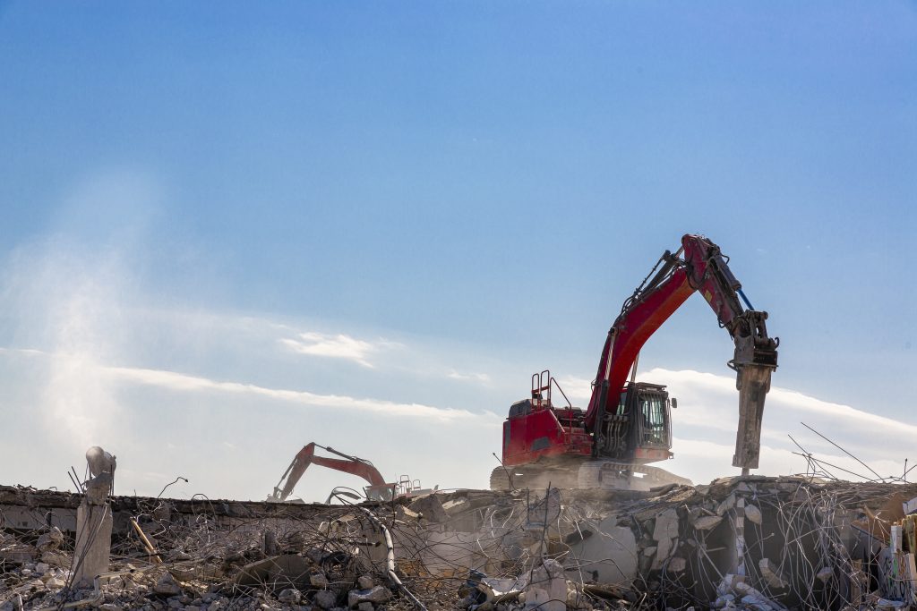 Excavator with a hydraulic hammer on a demolition site